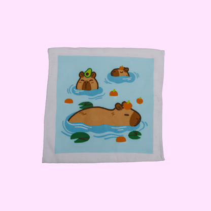 Capybara - Magisches Baumwollhandtuch 30x30cm - Drei Capybara mit blauem Hintergrund - SNACKS24.AT
