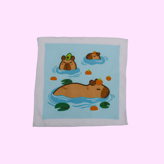 Capybara - Magisches Baumwollhandtuch 30x30cm - Drei Capybara mit blauem Hintergrund - SNACKS24.AT